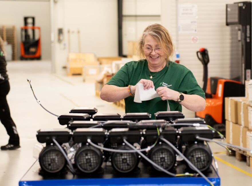 Green Instruments warehouse employee putting labels on products